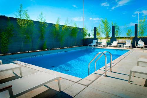 a swimming pool with tables and chairs on a building at Element Dallas Fort Worth Airport North in Irving