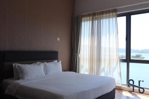 a bedroom with a bed and a large window at Homesuite' Home at The Loft in Kota Kinabalu