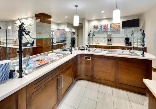 a large kitchen with wooden cabinets and a sink at Staybridge Suites San Antonio - Schertz by IHG in Schertz