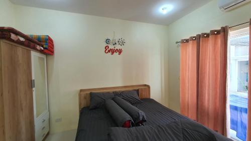 a bedroom with a bed and a sign on the wall at Family POOL VILLA CHAAM in Cha Am