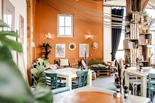 a living room with orange walls and tables and chairs at TinyParks Cast Away in Zuid-Beijerland