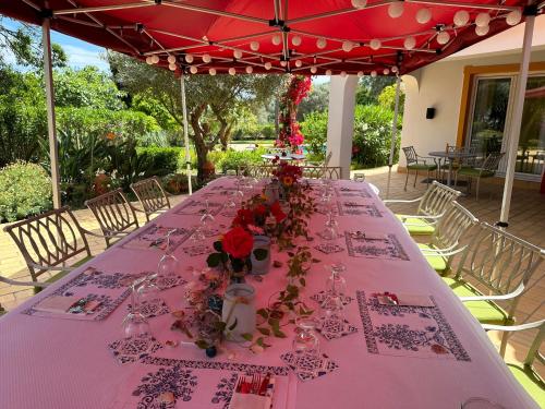 a long table with flowers and glasses on it at Villa Lagos Algarve for families & friends, 6 bedrooms, 7 bathrooms, pool, BBQ, central heating in Pedra Alçada