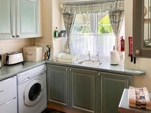 a kitchen with a sink and a washing machine at Pentargon View in Boscastle