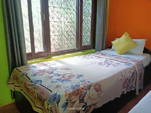 a bed in a room with a window at Hotel Butterfly - Peaceful Garden for Nature Lovers in Sauraha