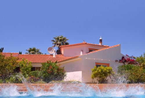 una casa con una fuente frente a ella en Villa Lagos Algarve for families & friends, 6 bedrooms, 7 bathrooms, pool, BBQ, central heating en Pedra Alçada