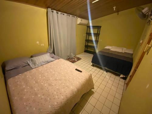 a small room with two beds and a window at La Casa de Cachi in Paquera