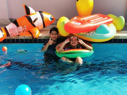 two people in the water in a swimming pool at Family POOL VILLA CHAAM in Cha Am
