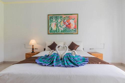 a bedroom with a bed with blue towels on it at Favorit Exclusive Villa & Bungalow in Nusa Penida