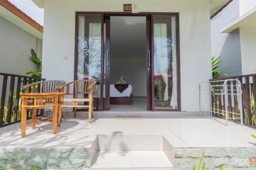 a patio with two chairs and a table on a house at Favorit Exclusive Villa & Bungalow in Nusa Penida