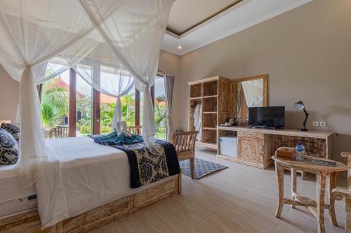 una camera con letto, televisore e tavolo di Favorit Exclusive Villa & Bungalow a Nusa Penida