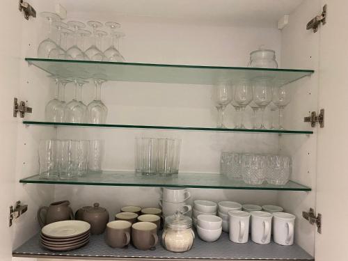 a shelf filled with glasses and other glass items at Altair Colombo - View, Location, Ultra Luxury! in Colombo