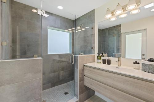 a bathroom with a shower and a sink and a mirror at Newly Remodeled House in Miami - 3BR House with Private Yard - 5 Min ride to Hollywood Beach in Hollywood