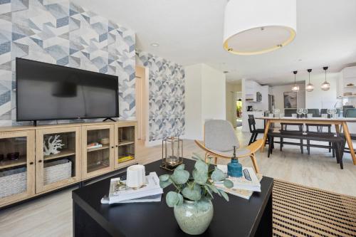 a living room with a tv and a table at Newly Remodeled House in Miami - 3BR House with Private Yard - 5 Min ride to Hollywood Beach in Hollywood