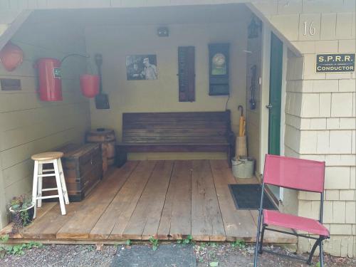 a porch with a bench and two chairs on it at Siltcoos Station in Siltcoos
