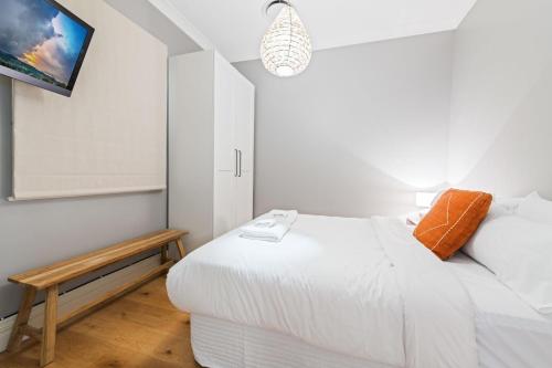 a white bedroom with a bed and a tv at Belle Cottage on March - Central High-End Heritage in Orange