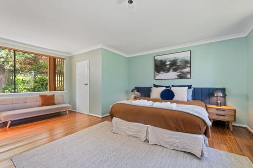 a bedroom with a large bed and a couch at Bendalong - Rural Retreat, Short Drive to CBD in Orange