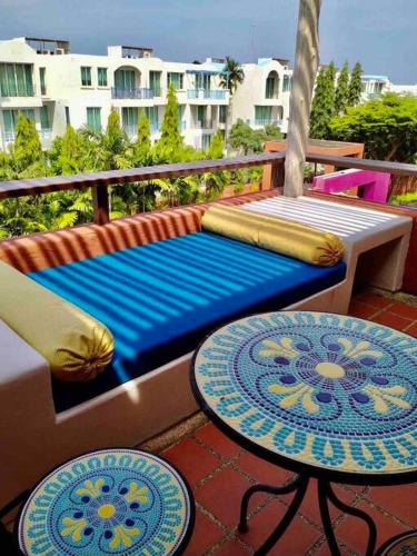 a couch and two tables on a balcony at Las Tortugas, Cozy condominium on Khao Tao beach, Hua Hin in Khao Tao
