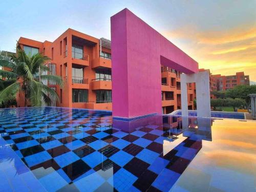 a swimming pool with a pink building and a building at Las Tortugas, Cozy condominium on Khao Tao beach, Hua Hin in Khao Tao