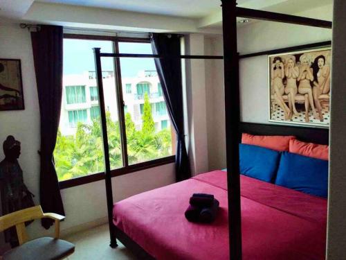 a bedroom with a red bed and a window at Las Tortugas, Cozy condominium on Khao Tao beach, Hua Hin in Khao Tao