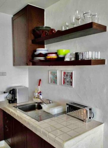 a kitchen counter with a sink and a microwave at Las Tortugas, Cozy condominium on Khao Tao beach, Hua Hin in Khao Tao