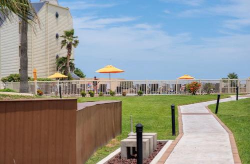 a walkway with a fence and umbrellas in a park at Upscale Modern Villa Private w Terrace in Bahia Mar Beachfront Resort, Heated Pool! in South Padre Island