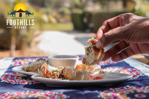 a person eating a sandwich on a table at Foothill Pushkar Resort in Pushkar