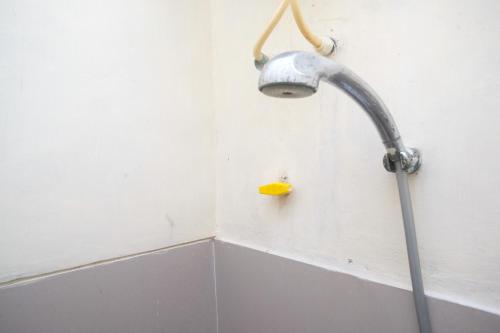 cabezal de ducha en una esquina del baño en RedDoorz at Putri Syariah Brebes 