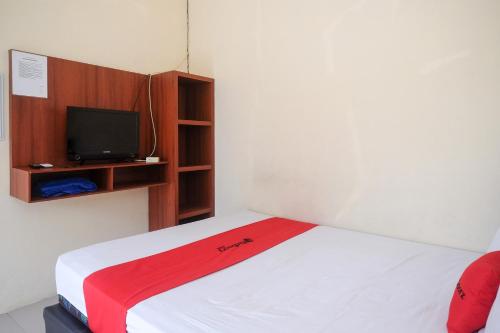 una camera con letto e TV a parete di RedDoorz at Putri Syariah Brebes 