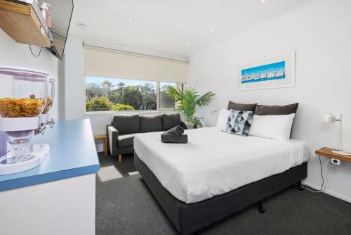 a bedroom with a king sized bed and a couch at Moody's Motel in Blairgowrie