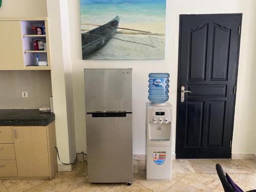 a kitchen with a refrigerator and a picture of a boat at 5 Bedroom Holiday Villa - Kuta Regency B8 in Kuta