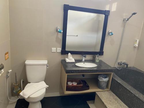 a bathroom with a toilet and a sink with a mirror at 5 Bedroom Holiday Villa - Kuta Regency B8 in Kuta