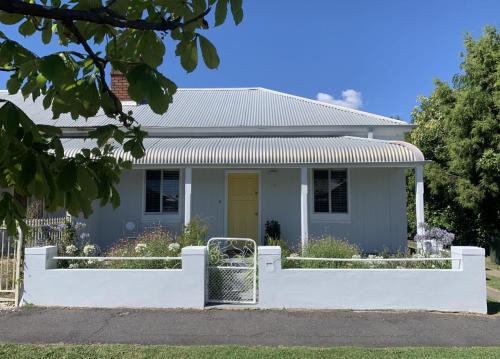 a house with a white fence in front of it at Mary Lemon Cottage - Heritage Home in Orange