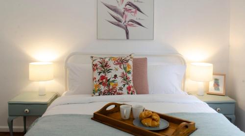 a tray with two teddy bears and two cups on a bed at Mary Lemon Cottage - Heritage Home in Orange