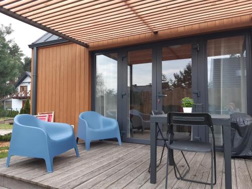 a deck with a pergola and a table and chairs at Przyjazne domki in Lubogoszcz