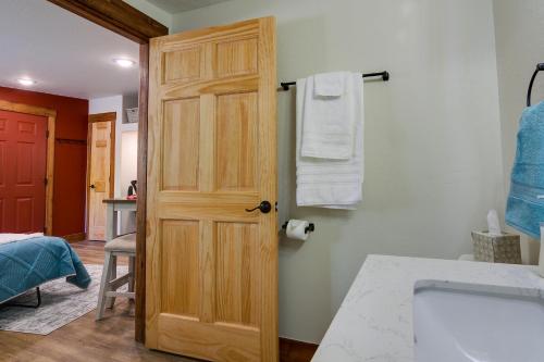 a bathroom with a wooden door and a sink at Southern Colorado Rental 10 Mi to Mesa Verde in Cortez