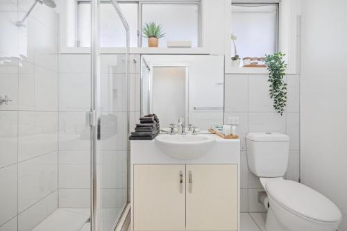 a white bathroom with a toilet and a sink at Moody's Beach Apartment in Blairgowrie