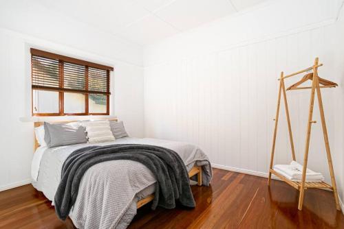 a white bedroom with a bed and a window at 2-bedroom Cottage in Redcliffe - 6A in Redcliffe