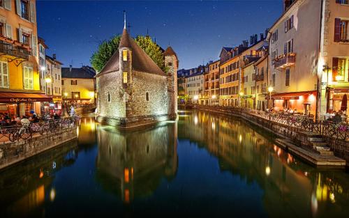 un canal en medio de una ciudad por la noche en Joli studio proche vieille ville + parking, en Annecy