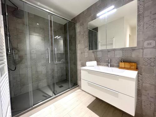 La salle de bains est pourvue d'une douche, d'un lavabo et d'un miroir. dans l'établissement Lakeside Attic, à Lugano