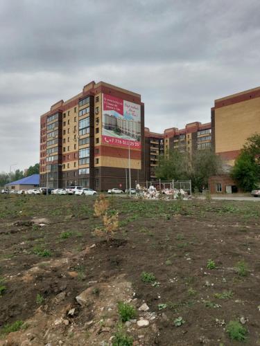 an empty field in front of a building at Абая 244 in Uralsk