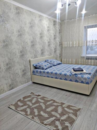 a bedroom with a bed and a rug at Абая 244 in Oral