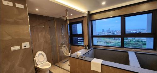 a bathroom with a shower and a toilet and a window at 楓葉閣溫泉會館Hot Spring Hotel in Hsin-hsing