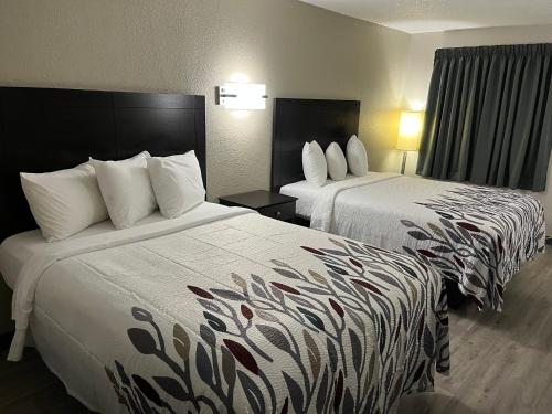 Habitación de hotel con 2 camas con sábanas blancas en Red Roof Inn Kimball, TN I-24 en Kimball