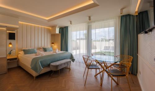 Habitación de hotel con cama, mesa y sillas en Gold Wave Apartments, en Siófok