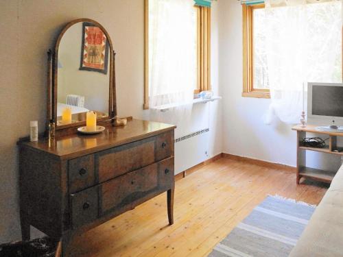 a bathroom with a dresser with a mirror and a television at 4 person holiday home in UDDEVALLA in Uddevalla