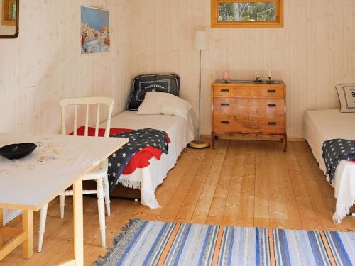 ウッデバラにあるHoliday home UDDEVALLA IIIのベッド2台、テーブル、ドレッサーが備わる客室です。