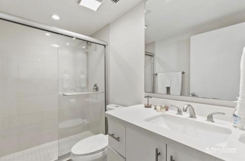 a bathroom with a toilet and a sink and a shower at Bahia Mar Beautiful Beachfront Condo! in South Padre Island