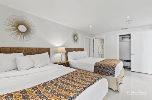a bedroom with two beds and a mirror on the wall at Ocean Breeze Retreat 2bed 2bath, Heated Pool! in South Padre Island