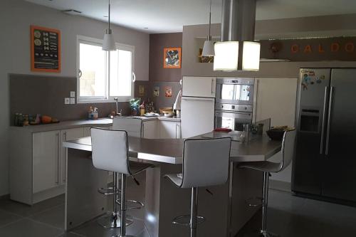 uma cozinha com um balcão com cadeiras e um frigorífico em Proche avignon, pont du gard,nuitee possible em Rochefort-du-Gard