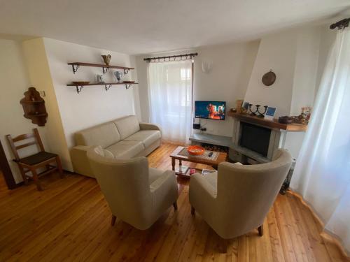 a living room with a couch and chairs and a television at Casa Ornella in Courmayeur